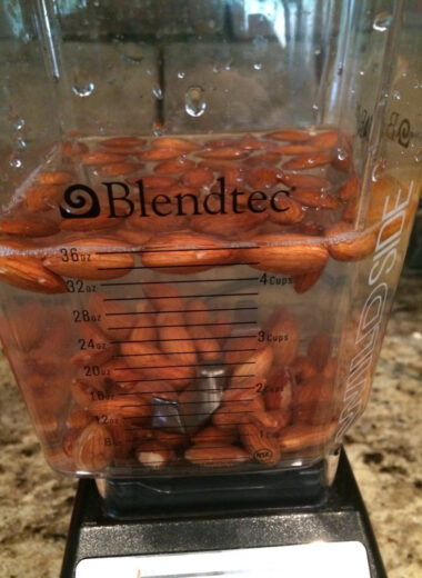 A blender with almonds and water in it to make almond milk.