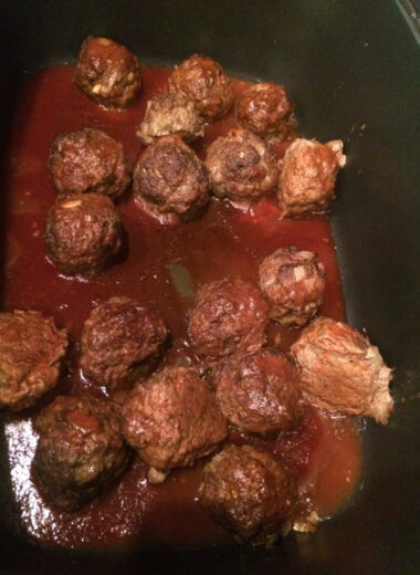 A pot full of meatballs covered in bbq sauce.