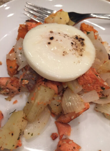A white plate with salmon, vegetables and a poached egg on it.