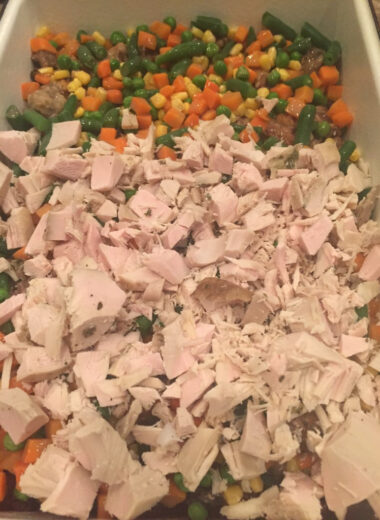 A casserole dish full of layered leftover foods from Thanksgiving.