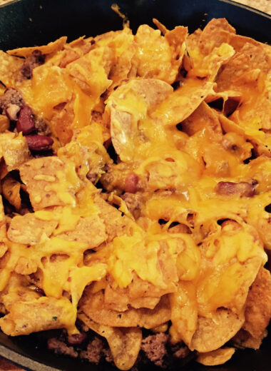 A cast iron skillet with ground buffalo meat, tortillas and cheese layered and baked.