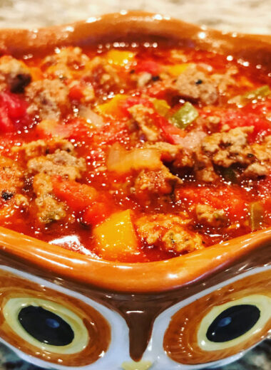A bowl that looks like an owl holding a delicious looking meat sauce.