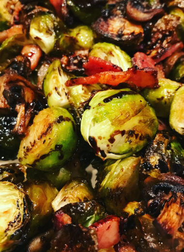 A pan full of roasted veggies with balsamic drizzle on top.
