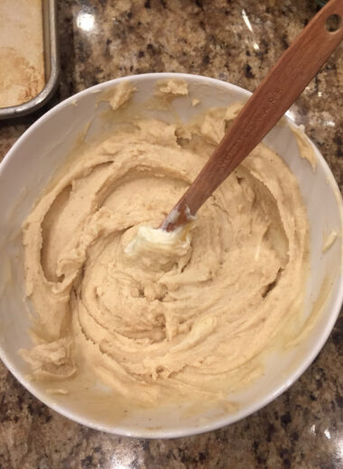 A white bowl with creamy sauce in it and a spatula that had stirred it.