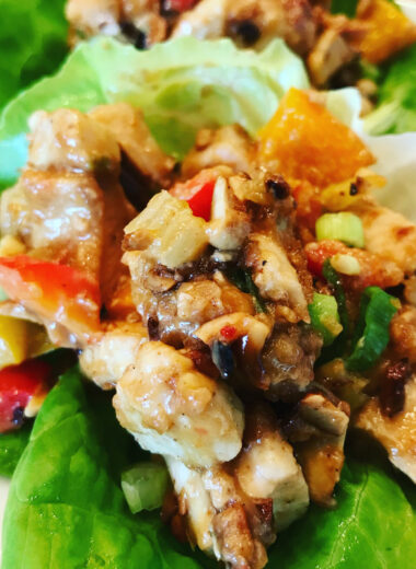 A lettuce cup filled with chicken and vegetables in a delicious sauce.