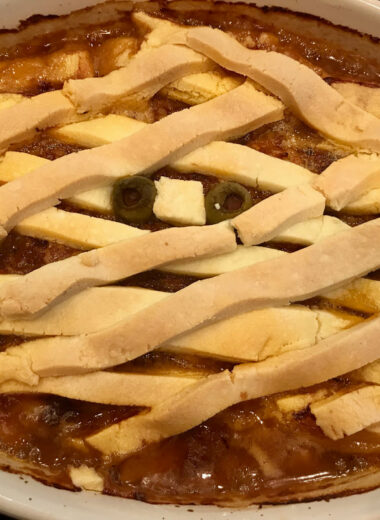 A baking dish with pie crust over meatloaf in the design of a mummy.