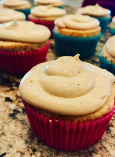 Cupcakes with pretty colored wrappers and white frosting.