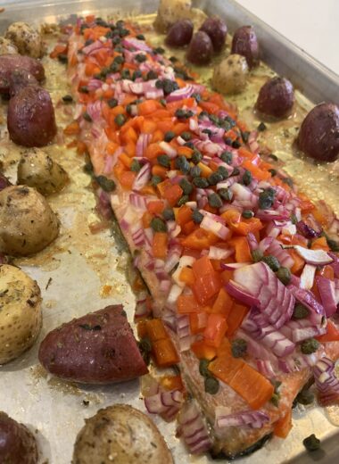 A sheet pan with roasted potatoes and salmon on it.