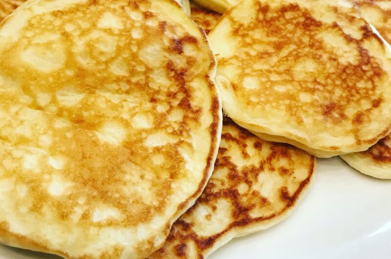 A plate with fluffy gluten free pancakes on top of it.