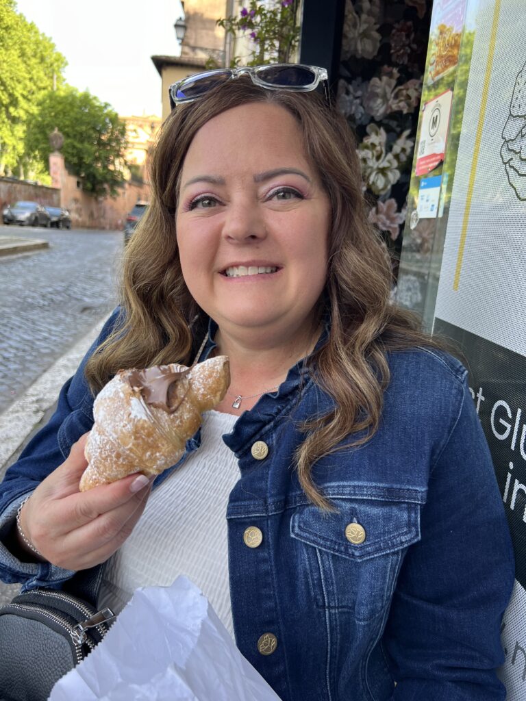 A lady holding a gluten free croissant in Rome